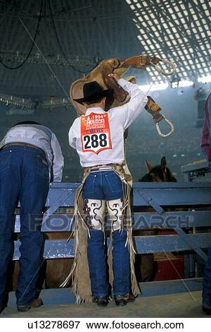 cowboy putting a saddle on his horse at the rodeo View Large Photo Image Stock Photo - cowboy putting a saddle on his horse at the rodeo. Fotosearch