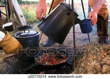 Picture - fresh food and drinks being cooked over a campfire. Fotosearch