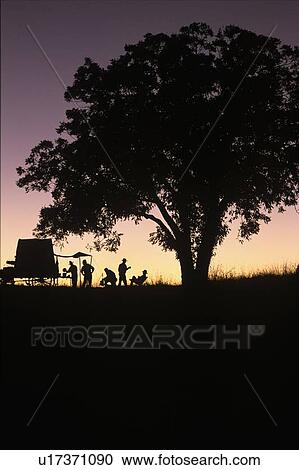 group cooking and eating at a site behind an old wagon View Large Photo Image Stock Image - group cooking and eating at a site behind an old wagon. Fotosearch
