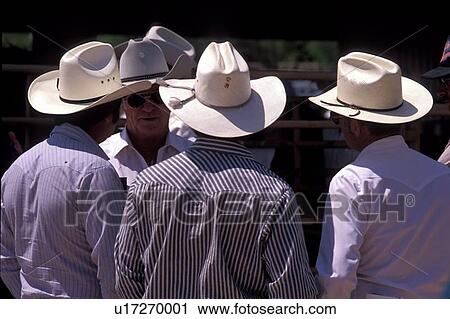 Stock Image - group of four men in cowboy hats standing outside talking. Fotosearch