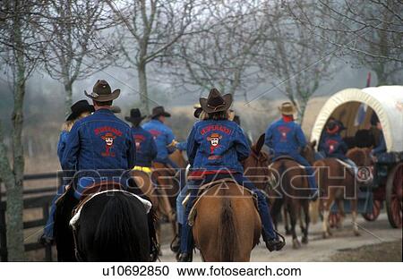 Stock Image - group of people riding horses in a trail ride. Fotosearch
