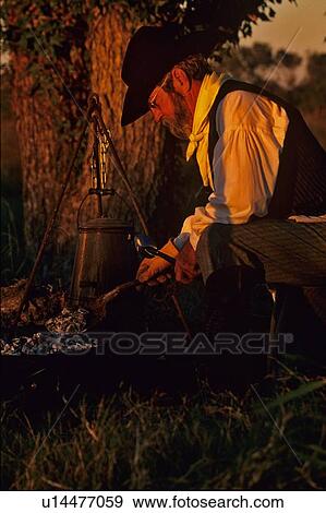 man cooking at a campfire View Large Photo Image Stock Photo - man cooking at a campfire. Fotosearch