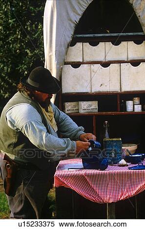 Stock Photography - man cooking at an old western wagon. Fotosearch