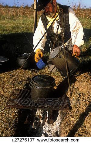 man pouring a hot drink over the campfire View Large Photo Image Stock Photo - man pouring a hot drink over the campfire. Fotosearch