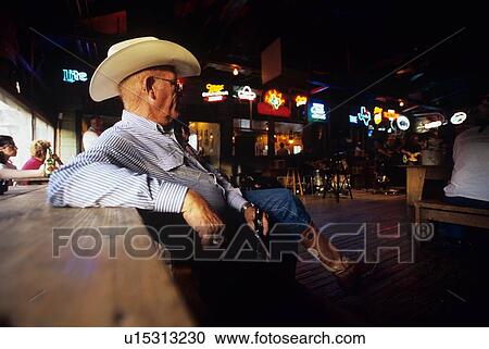 Stock Image - older man at a bar with a drink. Fotosearch