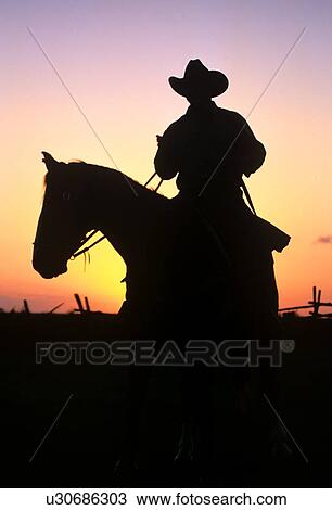 Stock Image - silhouette of a cowboy riding a horse. Fotosearch