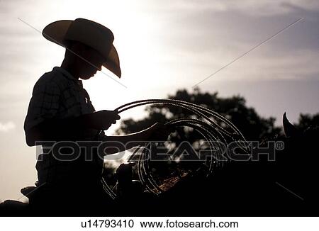 silhouette of a cowboy riding with a lasso View Large Photo Image Stock Image - silhouette of a cowboy riding with a lasso. Fotosearch