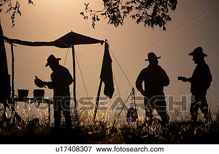 silhouette of three men standing at an old western campsite View Large Photo Image Stock Photo - silhouette of three men standing at an old western campsite. Fotosearch
