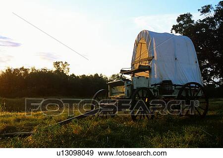 Stock Photo - western wagon sitting in a field. Fotosearch