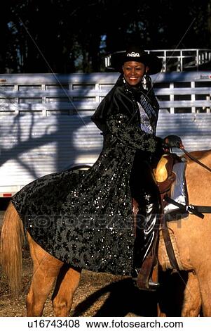 Stock Photo - woman riding a brown horse. Fotosearch