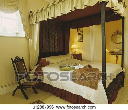 クリーム そして ブラウン ドレープ 上に 4 ポスターベッド 中に クリーム 寝室 で Victorian 椅子 横に ベッド 画像コレクション U Fotosearch