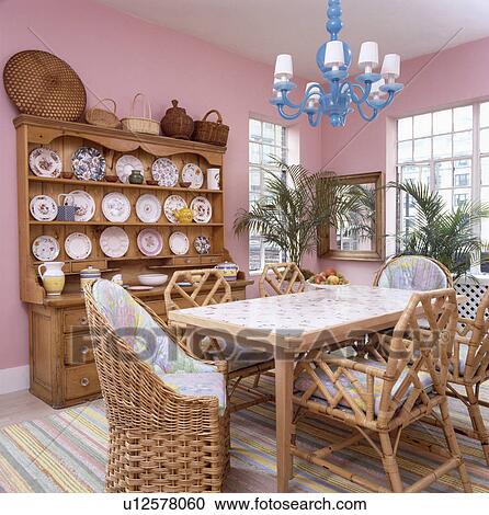 藍色 木頭 枝形吊燈 上面 桌子 由于 柳條 以及 藤條 椅子 在 粉紅色 八十 餐廳 由于 大 松樹 化妝師種類最齊全的圖像 U