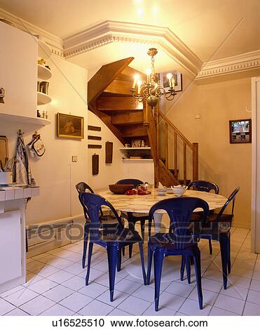 青 プラスチック 椅子 そして 円 白 テーブル 中に 地下室 台所 で 白 フロアタイル そして 木製である 階段 ストックイメージ U Fotosearch