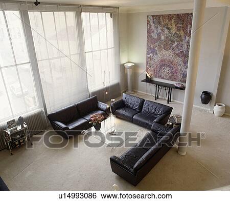 Stock Photograph - Aerial view of black leather sofas in modern white living room. Fotosearch