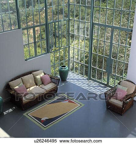 Aerial view of modern living room with large windows and cane furniture View Large Photo Image Stock Photography - Aerial view of modern living room with large windows and cane furniture. Fotosearch
