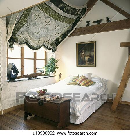 Antique chest at the end of the bed in attic country ...