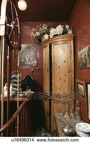 Picture - Antique pine corner-cupboard in small red dining room. Fotosearch