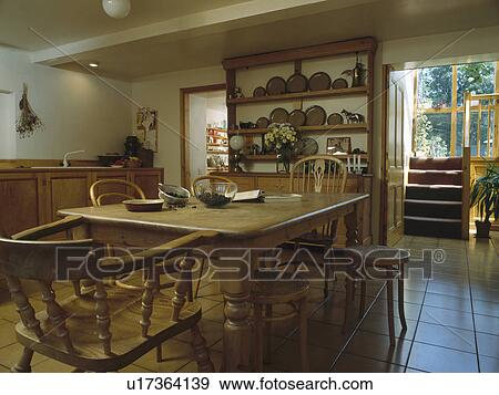 Stock Photo - Antique pine table and chairs in diningroom with low ceiling and tiled floor. Fotosearch