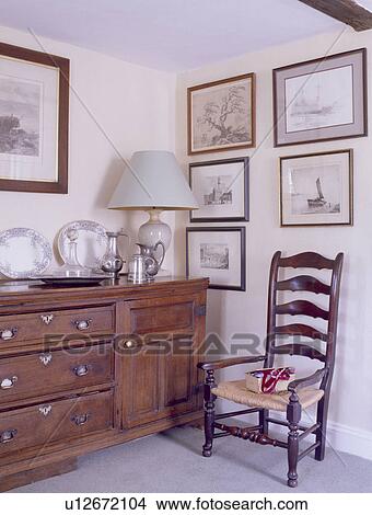 Antique sideboard and ladderback chair with rush seat in country dining room View Large Photo Image Picture - Antique sideboard and ladderback chair with rush seat in country dining room. Fotosearch