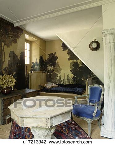 Antique table and blue upholstered chair in antique bedroom with pastoral mural painted on walls View Large Photo Image Stock Image - Antique table and blue upholstered chair in antique bedroom with pastoral mural painted on walls. Fotosearch