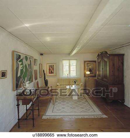 Antique table and white rug in uncluttered Scandinavian country living room with wooden floor View Large Photo Image Stock Photography - Antique table and white rug in uncluttered Scandinavian country living room with wooden floor. Fotosearch