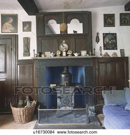 Antique wooden mirror above fireplace with cast-iron stove in cottage living room View Large Photo Image Picture - Antique wooden mirror above fireplace with cast-iron stove in cottage living room. Fotosearch