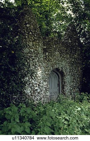 Picture - Arched door in stone wall in walled country garden. Fotosearch