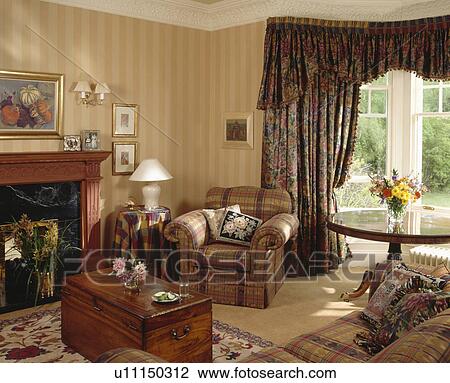Armchair beside fireplace in traditional living room with striped wallpaper and dark floral curtains View Large Photo Image Stock Image - Armchair beside fireplace in traditional living room with striped wallpaper and dark floral curtains. Fotosearch
