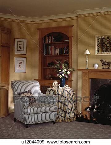 Stock Photo - Armchair beside fireplace in traditional living room. Fotosearch