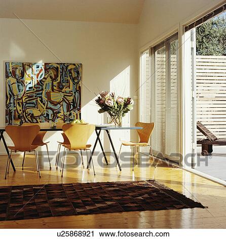 Arne Jacobsend Ant chairs in modern white dining room with large picture on wall and open French doors to patio View Large Photo Image Stock Image - Arne Jacobsend Ant chairs in modern white dining room with large picture on wall and open French doors to patio. Fotosearch