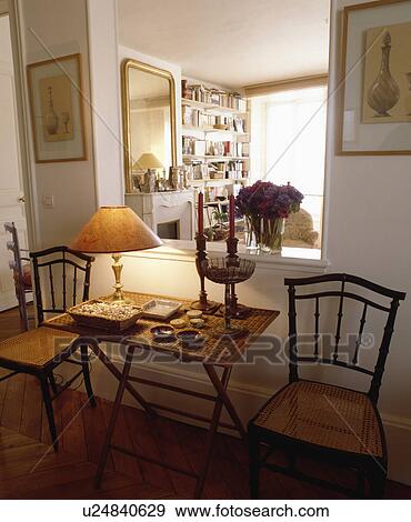 Bamboo table between antique chairs with cane seats below large aperture in hall wall View Large Photo Image Stock Photo - Bamboo table between antique chairs with cane seats below large aperture in hall wall. Fotosearch
