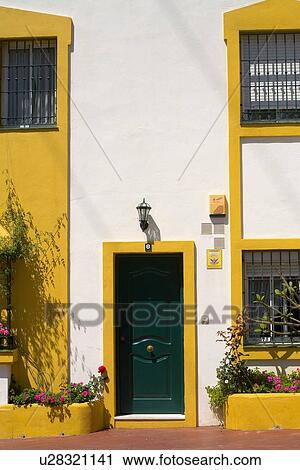 Black door on white Spanish house with yellow door and window frames View Large Photo Image Stock Image - Black door on white Spanish house with yellow door and window frames. Fotosearch