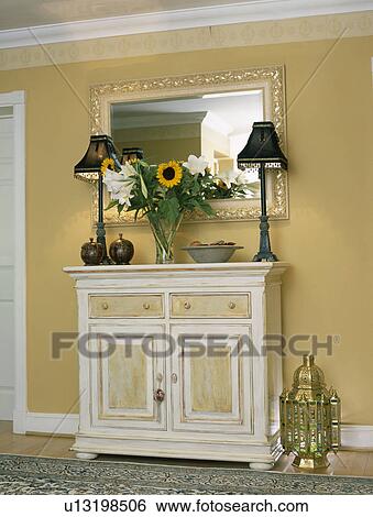 Stock Photograph - Black lamps on painted cream cupboard in neutral hall. Fotosearch