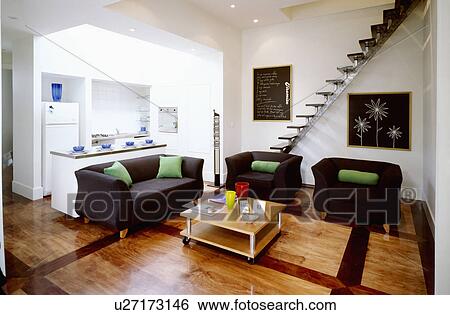 Black sofa and armchairs in modern white openplan living room with wooden flooring View Large Photo Image Stock Photograph - Black sofa and armchairs in modern white openplan living room with wooden flooring. Fotosearch