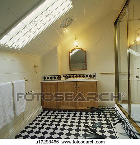 Black+white chequerboard ceramic floor tiles in modern attic shower room with fitted pine vanity unit View Large Photo Image Stock Photograph - Black+white chequerboard ceramic floor tiles in modern attic shower room with fitted pine vanity unit. Fotosearch