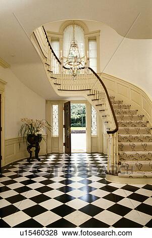 Stock Photo - Black+white chequerboard floor in Georgian hall with curved staircase and door open to garden. Fotosearch