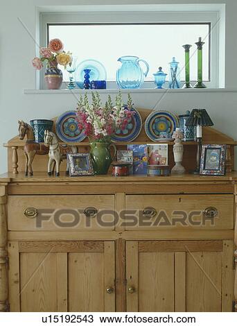 Blue and green glassware on small windowsill above pine sideboard with colourful ceramic plates View Large Photo Image Stock Image - Blue and green glassware on small windowsill above pine sideboard with colourful ceramic plates. Fotosearch