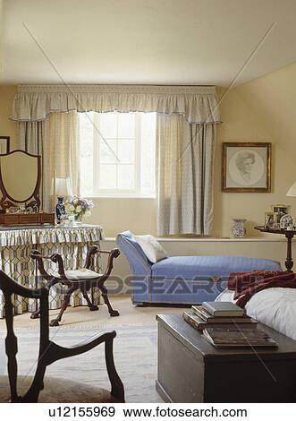 Blue chaiselongue and antique chest in neutral cottage bedroom View Large Photo Image Stock Photo - Blue chaiselongue and antique chest in neutral cottage bedroom. Fotosearch