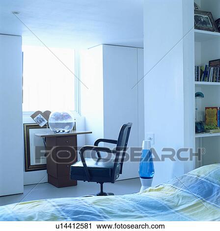 Blue lava lamp and black leather chair beside bed with checked linen in modern white bedroom View Large Photo Image Stock Image - Blue lava lamp and black leather chair beside bed with checked linen in modern white bedroom. Fotosearch