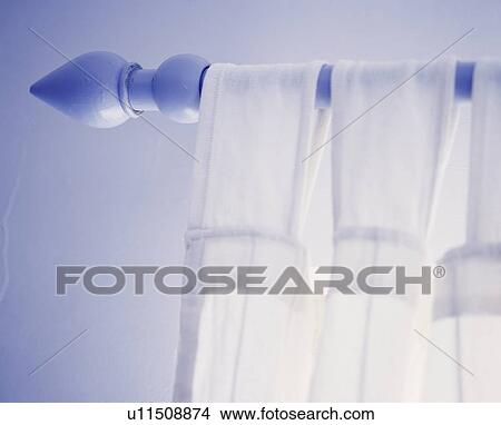 Picture - Blue painted curtain pole holding a sheer tab top curtain. Fotosearch