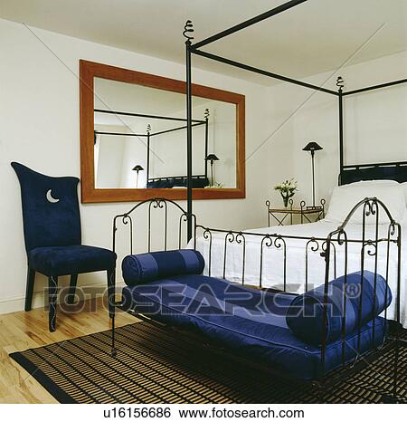 Stock Images Of Blue Striped Cushions On Metal Daybed Below Modern Blue Striped Cushions On Metal Daybed Below Modern Black Iron Four Poster Bed In White Bedroom With Chair