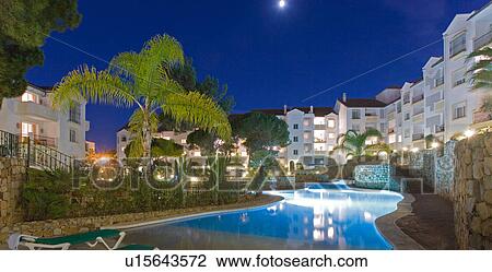 Blue swimmingpool in front of modern white apartment buildings in Spanish holiday village View Large Photo Image Stock Image - Blue swimmingpool in front of modern white apartment buildings in Spanish holiday village. Fotosearch