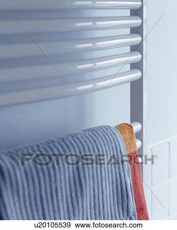 Stock Photo - Blue towel on white heated towel rail. Fotosearch