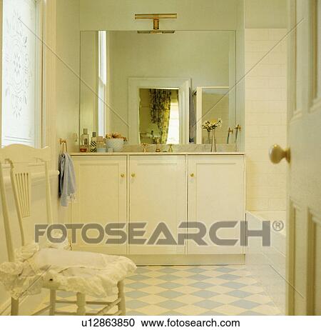 Blue+white chequerboard flooring in traditional bathroom with white fitted vanity unit below mirror View Large Photo Image Stock Image - Blue+white chequerboard flooring in traditional bathroom with white fitted vanity unit below mirror. Fotosearch