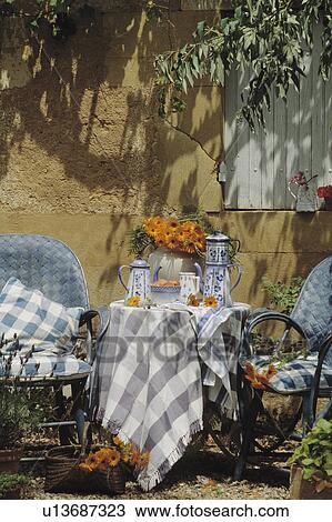 Blue+white cloth and pots on table in front of old stone wall in country garden in summer View Large Photo Image Stock Image - Blue+white cloth and pots on table in front of old stone wall in country garden in summer. Fotosearch