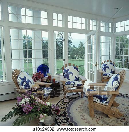 Blue+white cushions on Adirondack chairs in traditional conservatory living room View Large Photo Image Stock Image - Blue+white cushions on Adirondack chairs in traditional conservatory living room. Fotosearch