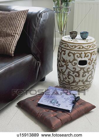 Ceramic Chinese stool and album on brown silk cushion beside black leather chair View Large Photo Image Stock Photo - Ceramic Chinese stool and album on brown silk cushion beside black leather chair. Fotosearch