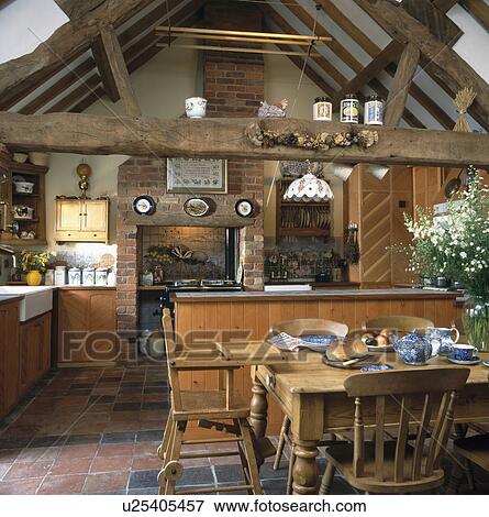Child's pine highchair at pine table in traditional kitchen dining room in converted barn with large wooden crossbeam View Large Photo Image Stock Photo - Child's pine highchair at pine table in traditional kitchen dining room in converted barn with large wooden crossbeam. Fotosearch