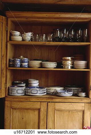 Stock Image - China and glassware on antique pine dresser. Fotosearch