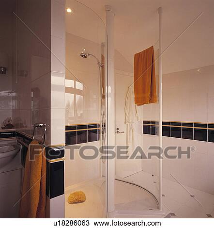 Circular glass shower cabinet in modern white tiled bathroom with black tiled border View Large Photo Image Stock Image - Circular glass shower cabinet in modern white tiled bathroom with black tiled border. Fotosearch